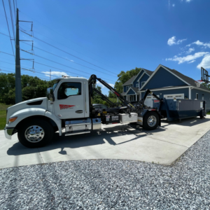 A Chet's Disposal roll-off truck delivering a dumpster to a residential home in Springfield, MA.