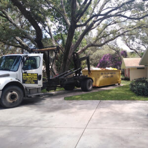 A roll-off truck delivering a Big Yellow Dumpster for a residential renovation project in Saint Petersburg, FL.