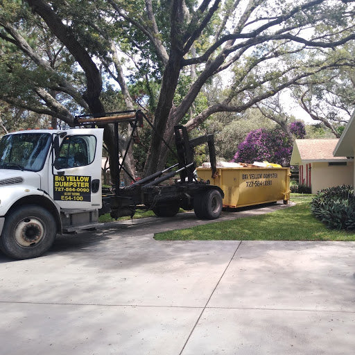 A roll-off truck delivering a Big Yellow Dumpster for a residential renovation project in Saint Petersburg, FL.