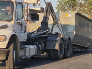 A Trash Panda roll-off truck with its hydraulic mechanism, ready for dumpster delivery or pickup in Carson City, NV.