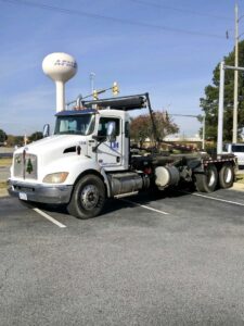 A white LDI roll-off truck parked in a lot, part of the fleet for Liberty Disposal, Inc. in Tucson, AZ.