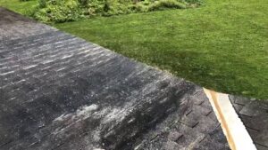 A dirty roof being cleaned, showcasing exterior maintenance by Phoenix's Cleaning Service, LLC in Rutland, VT.