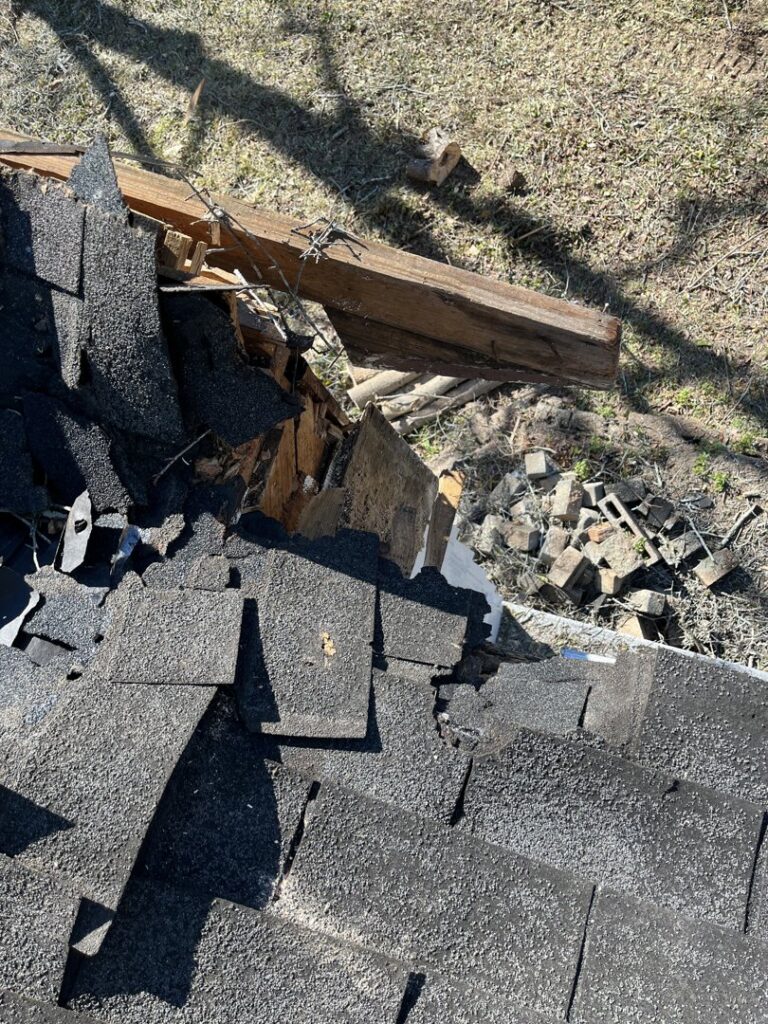 Close-up of roof damage caused by a fallen tree, indicating storm clean-up by Arbor Elite SC in Columbia, SC.