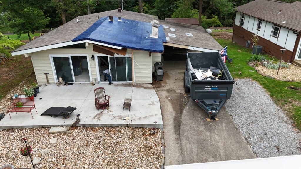 An aerial view of a Mobiledumps trailer filled with roof debris during a junk removal job in Rogers, AR.