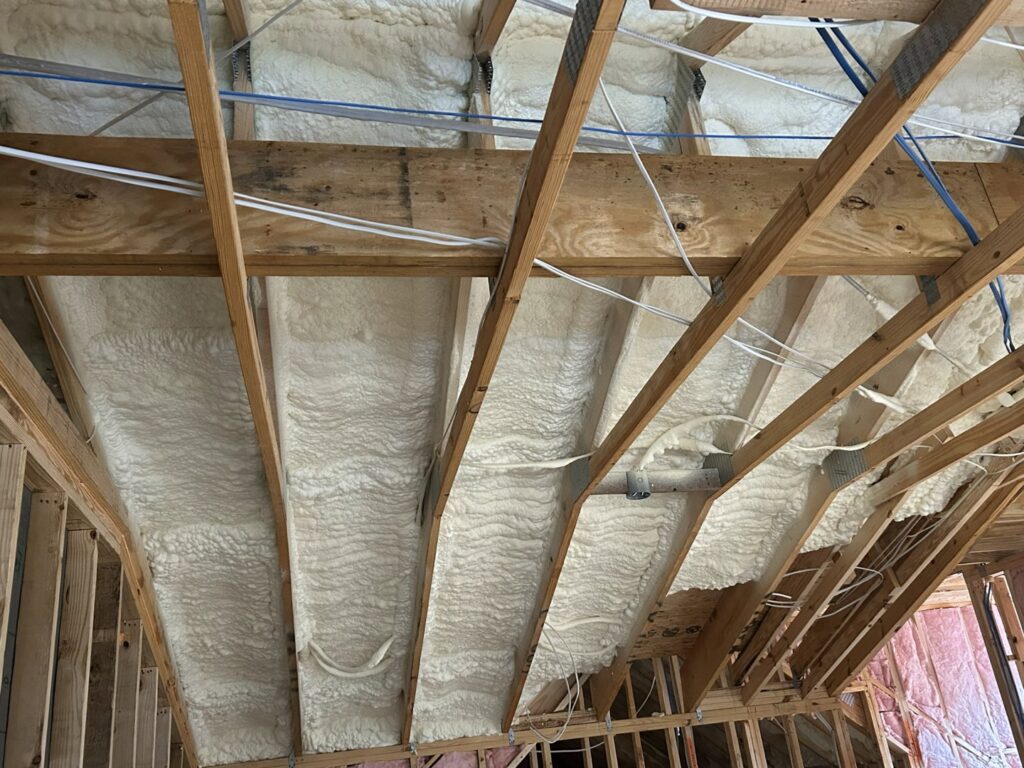 Spray foam insulation applied to a roof deck with wooden framing by Insulation By Cohen's in Moncks Corner, SC.