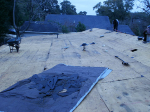 Roof decking exposed during shingle removal for a repair or replacement project by John Rowland Custom Homes in Macon, GA.