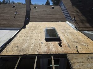 Exposed roof decking with a skylight, indicating preparation for new roofing material by Tillman's Handyman Service in Sparks, NV.