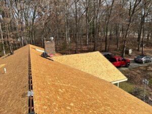 Plywood roof decking installed around a chimney, showing a stage of roof replacement by Roofing Experts Care in Charlotte, NC.