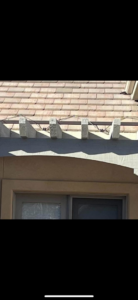 Detailed view of wires installed along the edge of a tiled roof above an outdoor structure by John's Helping Hand in Sparks, NV