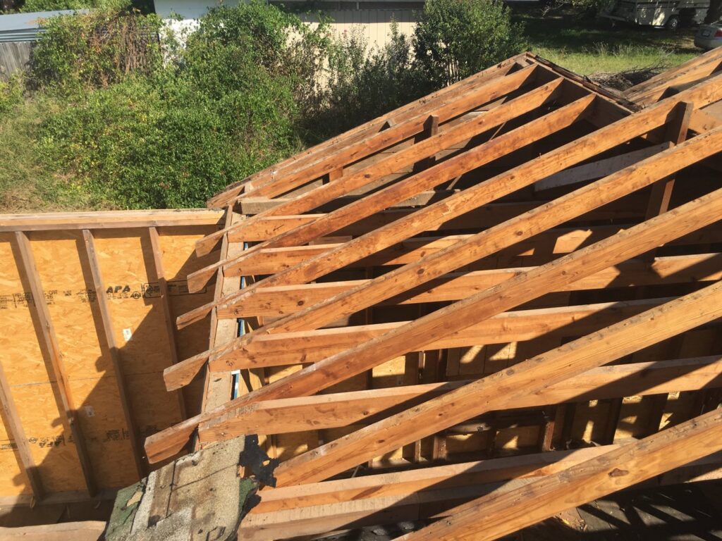 An aerial view of roof framing and exposed plywood sheathing during a construction project by Texas Wounded Veterans Builders and Contractors in McKinney, TX.