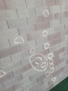 A roof with multiple chalk circles indicating hail damage during an inspection by RRC Reign Roofing & Construction in Oklahoma City, OK.