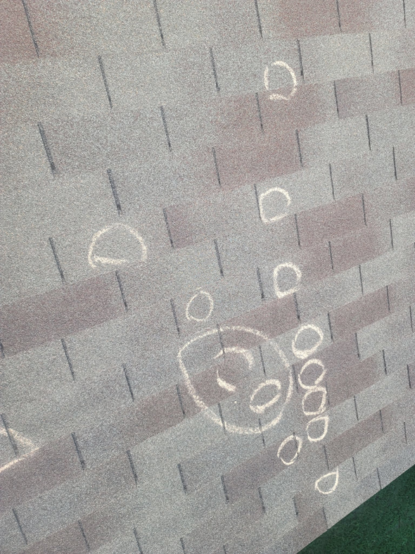 A roof with multiple chalk circles indicating hail damage during an inspection by RRC Reign Roofing & Construction in Oklahoma City, OK.