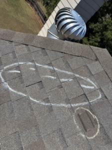 Roof inspection showing chalk marks and a vent on a shingle roof by Hansen Construction Stillwater in Stillwater, OK.