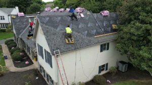 Aerial view of a roof installation underway with workers on the roof, a general contractor service by Moonshot Roofing in Columbia, PA.