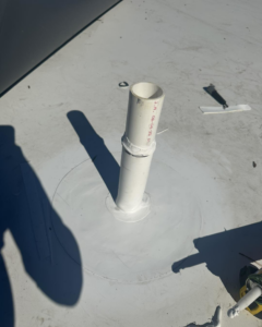 A pipe penetration on a flat roof expertly sealed to prevent leaks by Carolina DR & Roofing in Raleigh, NC.