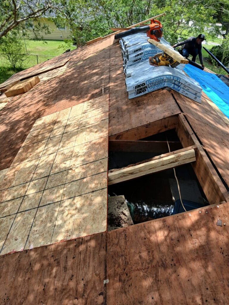 A close-up view of a roof showing exposed plywood and new plywood sections during repair by Coastal Roofing Solutions LLC in Charleston, SC.
