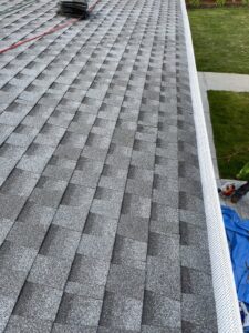 A worker performing roof repair or installation with tools and a tarp, a handyman service by Blue Wing Roofing in Augusta, GA