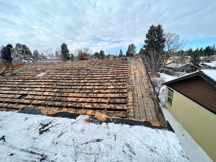A worker performing roof repair or replacement on a snowy roof for ALN Construction LLC in Hasbrouck Heights, NJ.