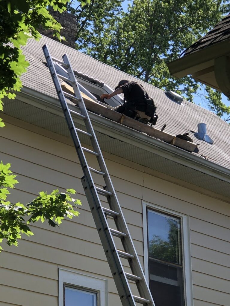 A handyman from Nordic Construction performing roof repair or skylight maintenance in Plymouth, MN.