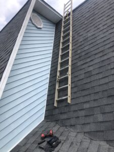 A ladder and handyman tools on a shingled roof, ready for repair work by Dream Construction in Johnson City, TN.