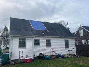 A house with a blue tarp on the roof for repair by JJJ Painting & Construction in Johnston, RI.
