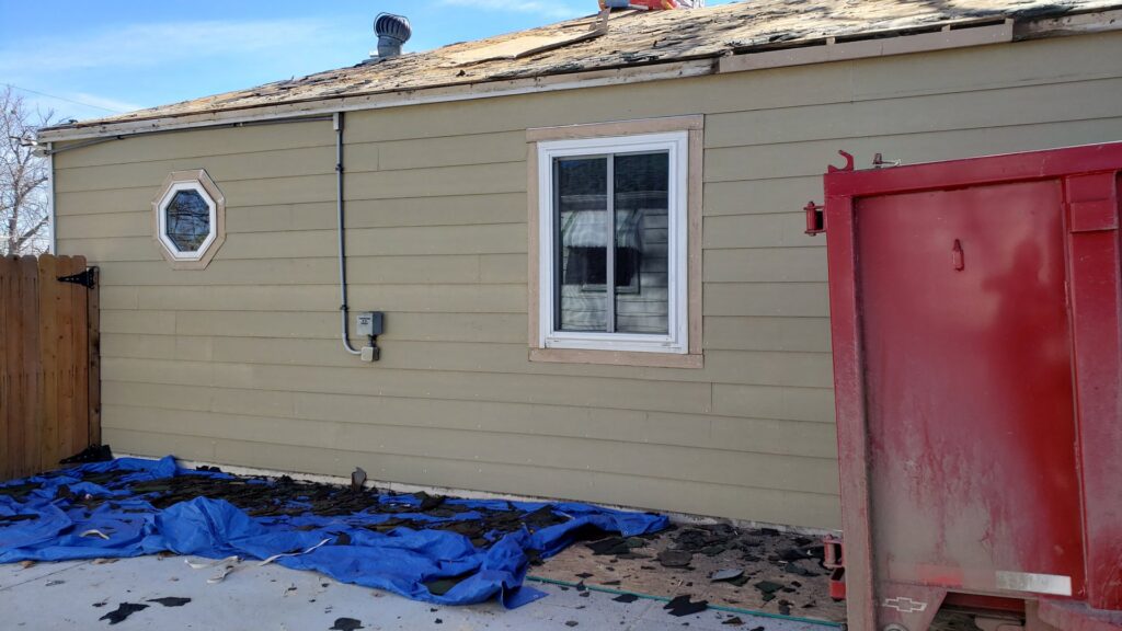 Roof replacement in progress with old shingles and debris collected in a dumpster by Roof Maxx of S Aurora, CO