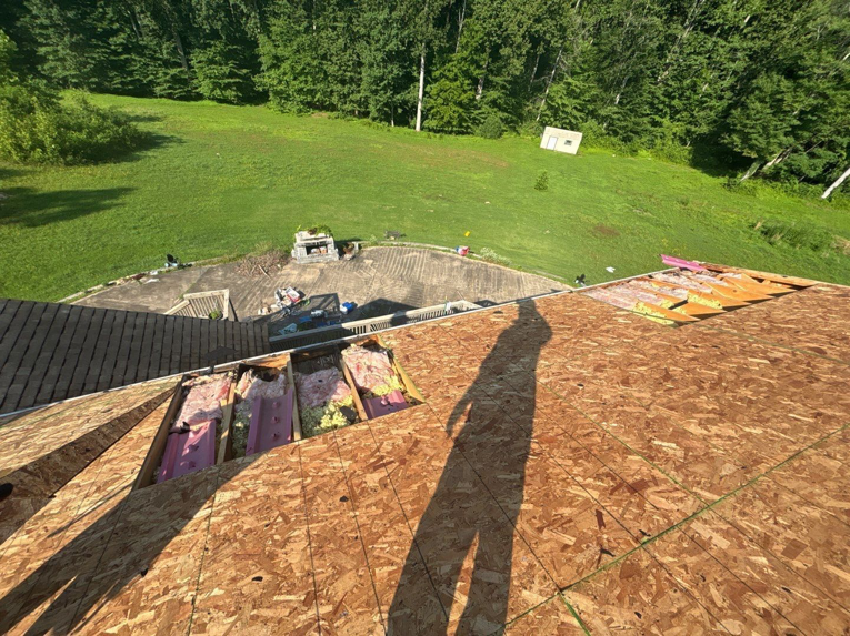 Roof replacement in progress showing exposed plywood decking and insulation by A&M Roofing in Springfield, VA.