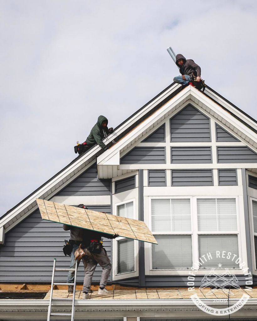 Workers performing roof and exterior restoration on a house for Roofsmith Restoration in Nashville, TN.