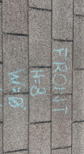 A shingle roof with blue chalk writing "FRONT" and "BACK" to mark sections for repair or replacement by Ramirez Roofing and Repair, LLC in Kansas City, MO.