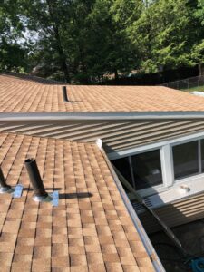 A residential roof with new shingles and a gutter guard system installed, showcasing roofing and gutter services by Home pro handyman llc in Olathe, KS
