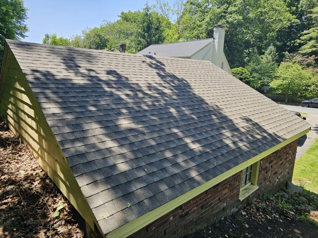 A newly installed shingle roof on a building, completed by Modern Remodel Build & Design in Worcester, MA.
