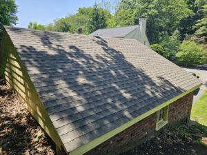 A newly installed shingle roof on a building, completed by Modern Remodel Build & Design in Worcester, MA.
