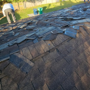 Workers removing old roof shingles during a renovation project by Dreamland USA in Hialeah, FL