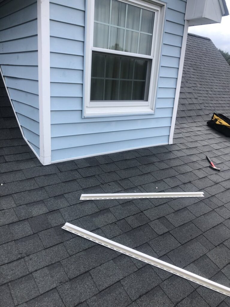 Roof and siding repair in progress, showing new trim pieces and a hammer by Dream Construction in Johnson City, TN.