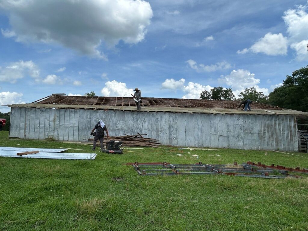 Workers preparing a roof structure for new metal roofing installation, a service from Roofing Experts Care in Charlotte, NC.