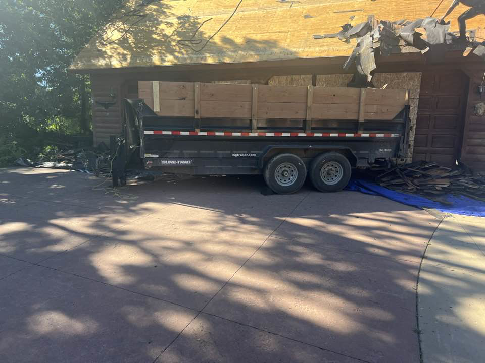 A dump trailer used for roof tear-off and debris removal at a home, provided by CRT Dump Trailer Rentals in Prior Lake, MN.