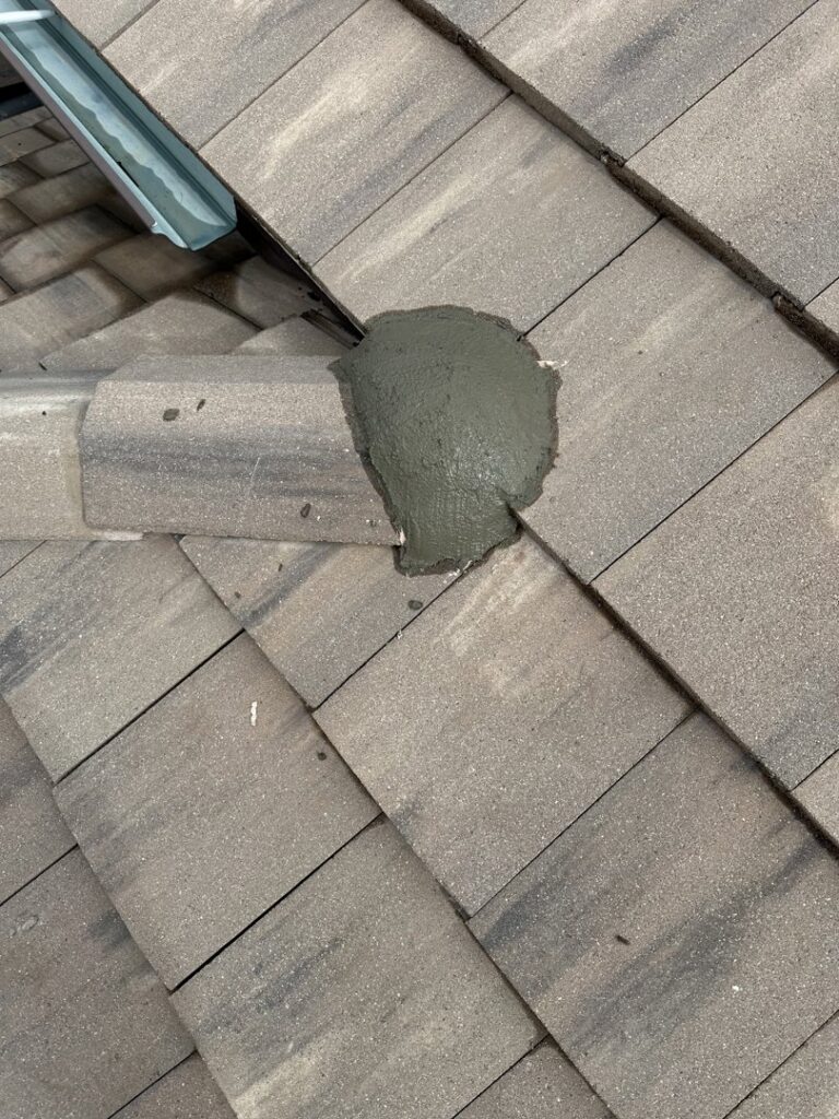 A roof tile with fresh cement or sealant applied during a repair by Peraza Handyman Services Llc in Bakersfield, CA.