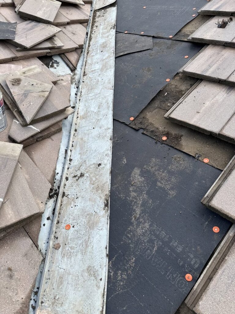 Roof tiles being replaced or repaired, showing the underlying waterproof membrane by Peraza Handyman Services Llc in Bakersfield, CA.