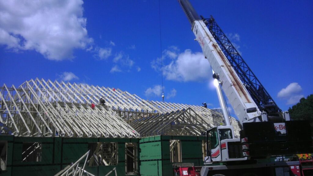 Roof trusses being installed on a large construction site by Mendez Contractor Inc in Lynn, MA