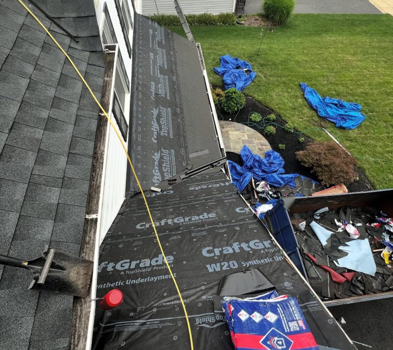 Roof underlayment installed on a house with a dumpster for debris removal by Goldstone Contracting Inc. in Gambrills, MD.
