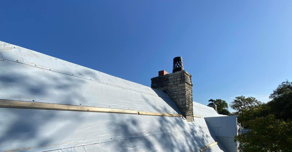 Roof underlayment and wooden battens installed around a chimney during a roofing project by J&J ultimate roofing llc in Austin, TX