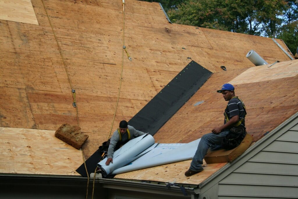 A crew installing roof underlayment on a residential house, a handyman service by Consolidated Roofing Systems, Inc. in Cary, NC