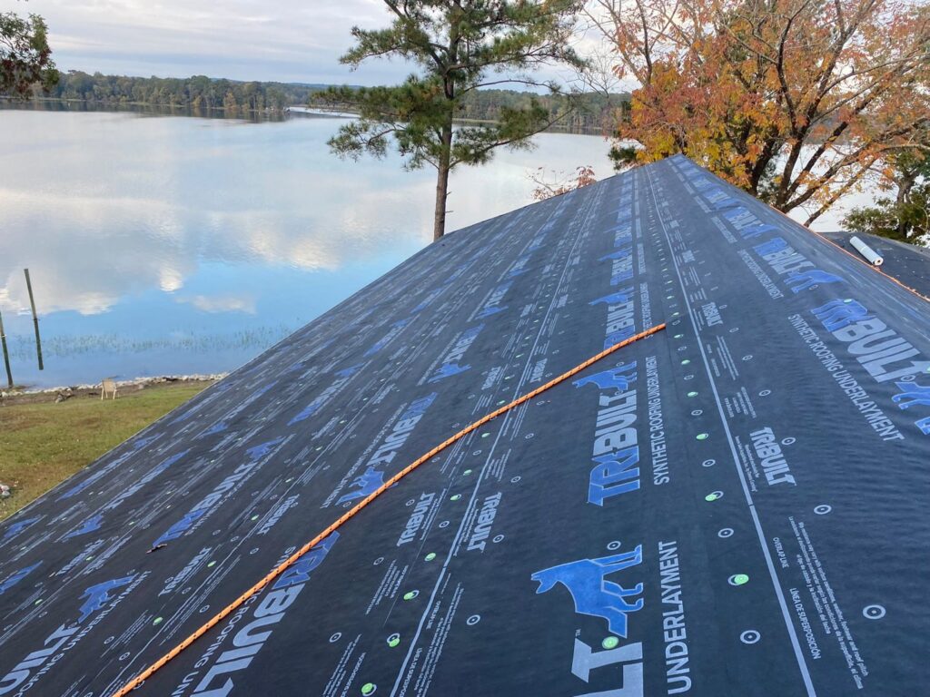 Synthetic roofing underlayment installed on a lakeside home, part of a project by Roofing Experts Care in Charlotte, NC.