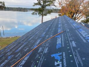 Synthetic roofing underlayment installed on a lakeside home, part of a project by Roofing Experts Care in Charlotte, NC.