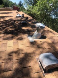 Various vents and pipes on a shingle roof, indicating maintenance by Elite Roofing Colorado Springs, CO.