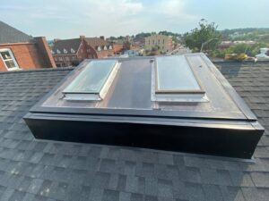A newly installed roof featuring two skylights, showcasing roofing expertise by Usa Construction of Danbury LLC in Danbury, CT.