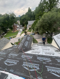 A roofer applying synthetic underlayment to a residential roof for Goldstone Contracting Inc. in Gambrills, MD.