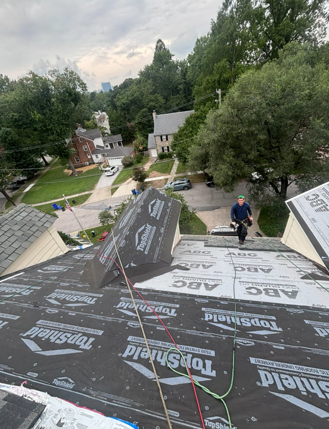 A roofer applying synthetic underlayment to a residential roof for Goldstone Contracting Inc. in Gambrills, MD.
