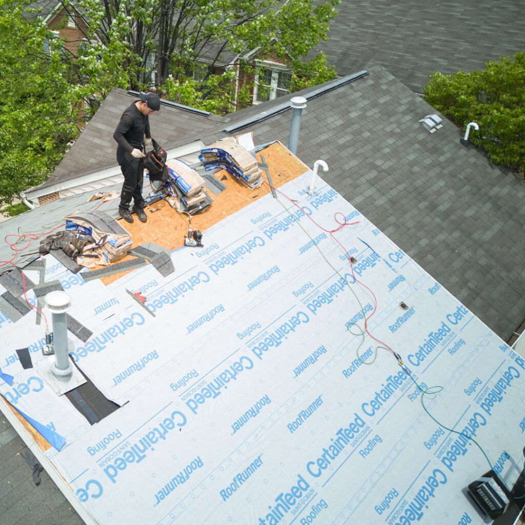 A roofer installing CertainTeed shingles on a residential roof, demonstrating a home improvement project by Four Seasons Home Improvement Company, Inc. in Rockville, MD.