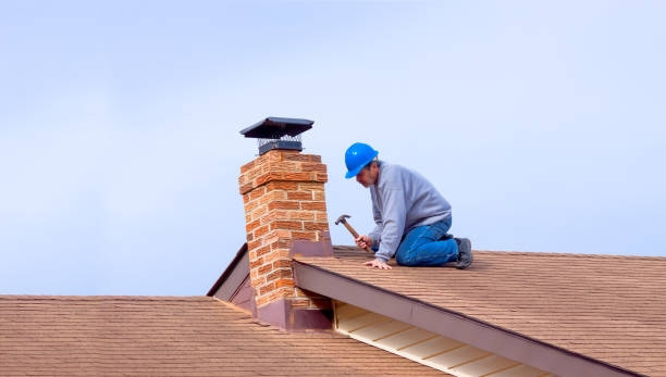 A roofer repairing a chimney and roof with a hammer for Chris Roofing & Remodeling Inc. in Colorado Springs, CO